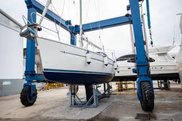 Boat lift carrying sailboats to storage during winter on land